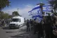 A convoy carrying the coffins of four bodies arrives at the 