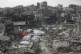 People walk amid the destruction caused by the Israeli air a