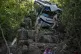 Security men inspect a bus that fell into a deep gorge on Su