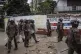 Police officers stand in front of graffiti calling for Kenya