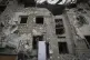 Local residents inspect heavily damaged buildings after the 