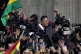 Bolivian President Luis Arce raises a clenched fist surround