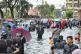 Residents walk on a flooded street after heavy monsoon rains