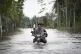 Residents ride on a self modified motorcycle through a road 
