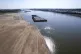 Barges float in the Mississippi River as a portion of the ri