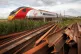 A Virgin train passes some rusting track at the side of the 