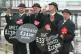 Four GMB protesters dressed as 'Fat Cat' business men pose w