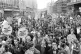 A massive column of demonstrators occupying the full width o