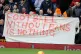 Fans hold up banners protesting against ticket prices during