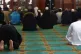 Men pray and listen to an Imam at a mosque in Birmingham