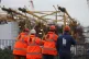 Workers watch their colleague work on a wind turbine jacket 