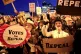 People carrying various signs gather outside The Custom Hous