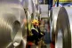 A worker inspects rolls of steel