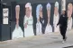 A woman passes a mural showing BAME medical, transport and c