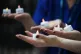 Nurses hold candles bearing the names of 235 health and soci