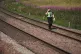 A police officer walks along the tracks at Carmont crossing,