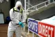 A ground staff disinfects the adverting boards during half t