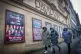 Members of the public walk past posters outside the Pavillon