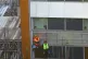 Workmen remove the cladding from the facade of a block of fl