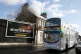 A bus decorated with a rainbow and NHS stickers passes a Cor