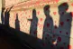 People are silhouetted against the COVID-19 Memorial Wall on
