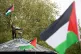 A protester waves the flag of Palestine whilst standing on t