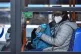 A person wearing a mask and gloves on a bus