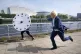 A man dressed as Prime Minister Boris Johnson races against 
