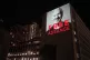 An image of Julian Assange is projected onto a building in L