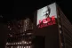 An image of Julian Assange is projected onto a building in L