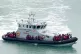 A group of people thought to be migrants are brought in to D