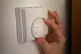 A person using a central heating thermostat