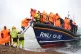 A group of people thought to be migrants are brought in to D