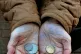 A pensioner holds some change in her hand