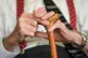 An elderly man holding a walking stick