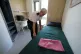 A prison officer adjusts the bedding inside a room within Ir