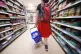 A shopper walking through the aisle of a supermarket