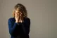 A woman with her hands covering her face