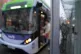 People board a bus in the rain in Glasgow, December 12, 2023