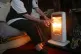 An elderly lady with her electric fire on at home in Liverpo