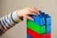 A preschool age child playing with plastic building blocks, 