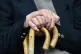 An elderly man holding a walking stick