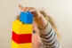 A preschool age child playing with plastic building blocks
