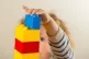 A preschool age child playing with plastic building blocks