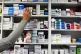 A pharmacist stocking shelves at a chemist