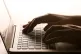 A woman's hands on a laptop keyboard