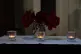 Three candles burn as members of the public attend a morning