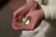 An elderly woman holding pound coins in her hands