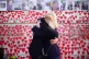 People hugging as they attend a ceremony marking the fifth a