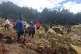 People cross over the landslide area to get to the other sid
